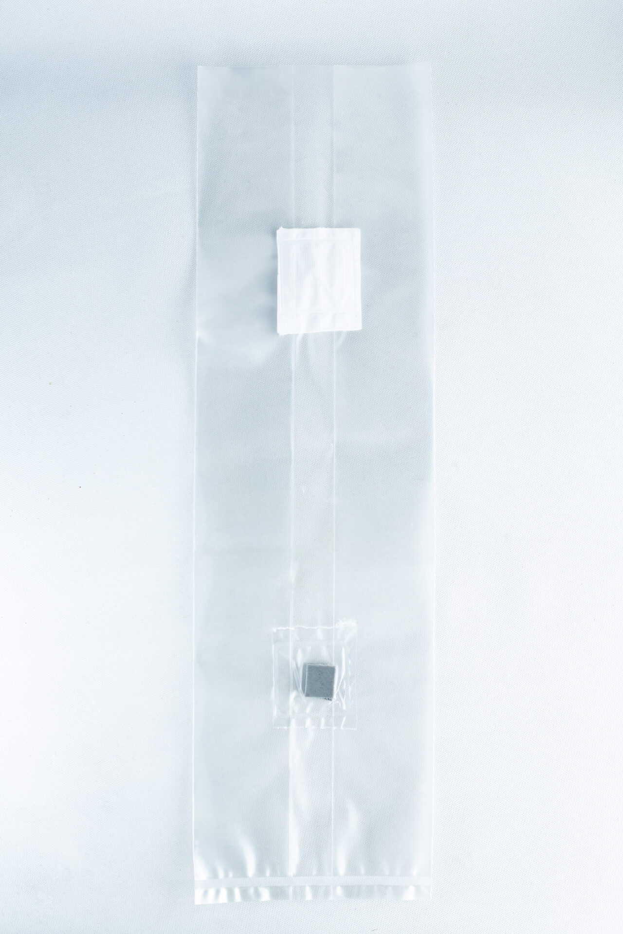 A clear plastic Mushroom Grow Bag Unicorn for spawn and substrate, featuring two small compartments with items inside, is displayed on a white background.