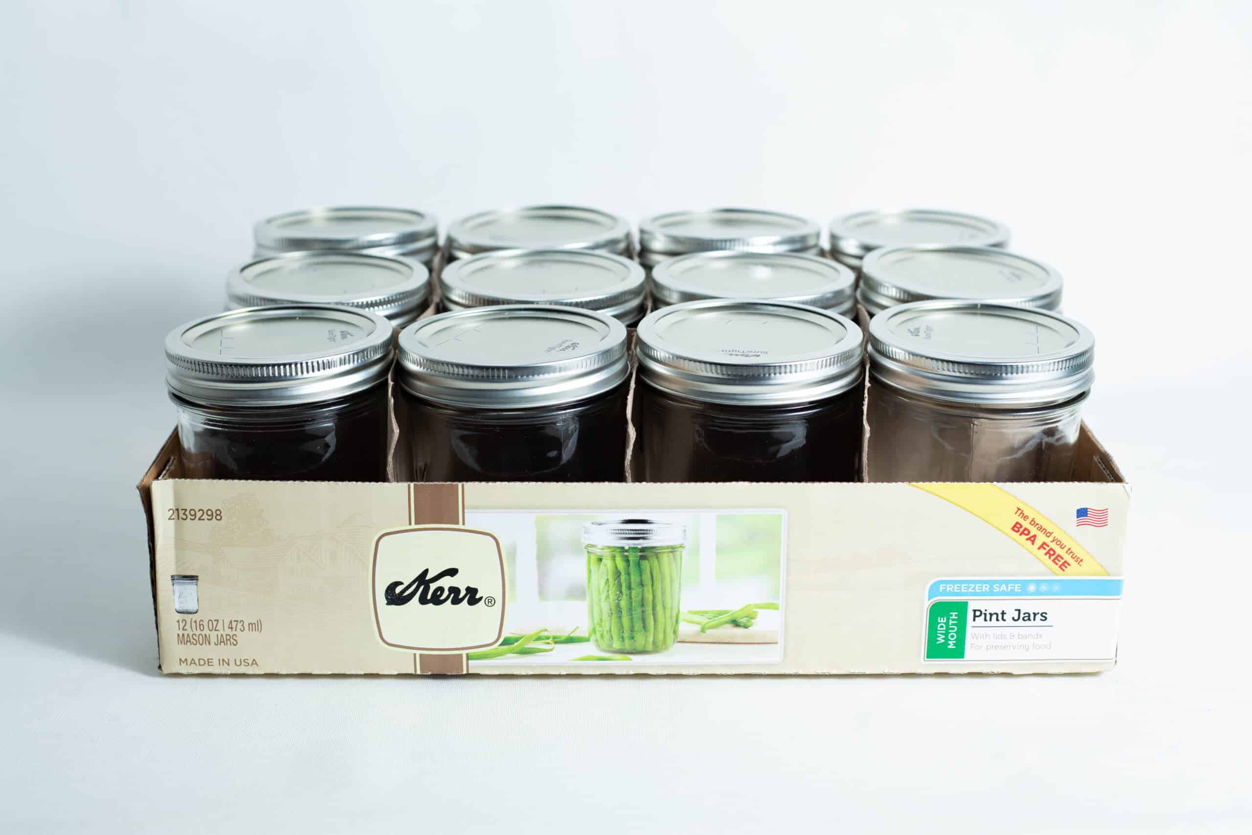 A box of twelve Kerr wide mouth Mason jars, each 473ml pint size with lids and bands, neatly arranged in three rows.