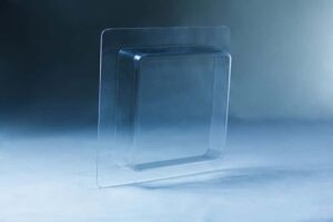Clear plastic blister packaging set against a blue-toned background, echoing the structured design of the Mycelium Mould Growth form – Paver (Reusable).