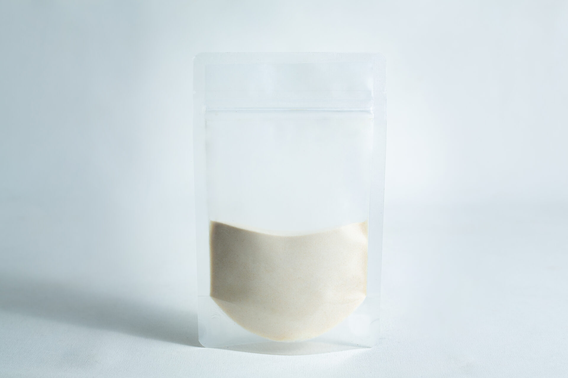 A clear resealable pouch, half-filled with light beige Agar Mix MYAG Antibacterial Malt Extract Yeast powder, shown on a plain white background.