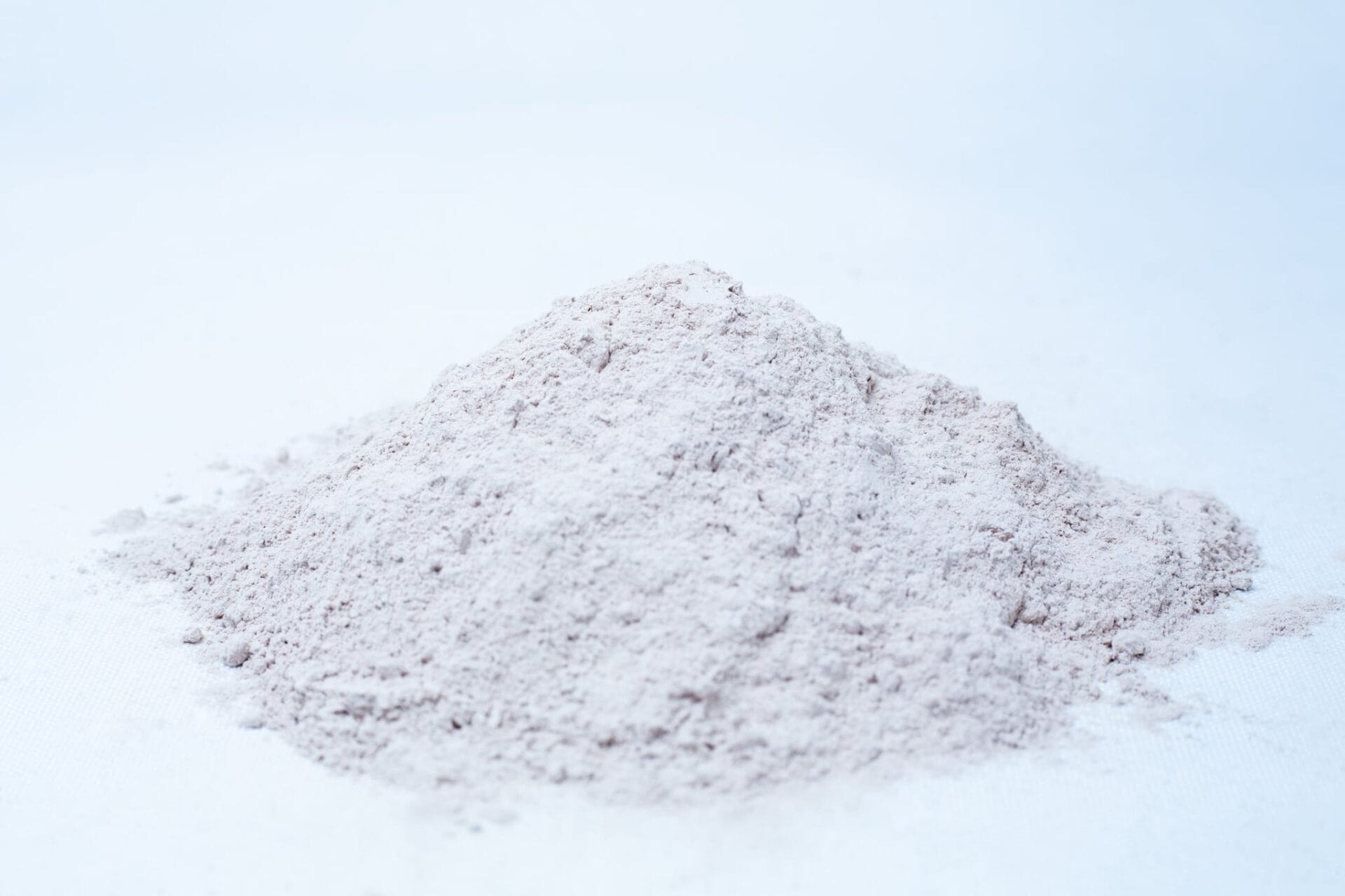A small mound of Liquid Culture Pre-mix | DLME | Now Extra Clear, a fine, light-coloured powder perfect for mixing dextrose and light malt extract, sits on a white surface against a plain background.