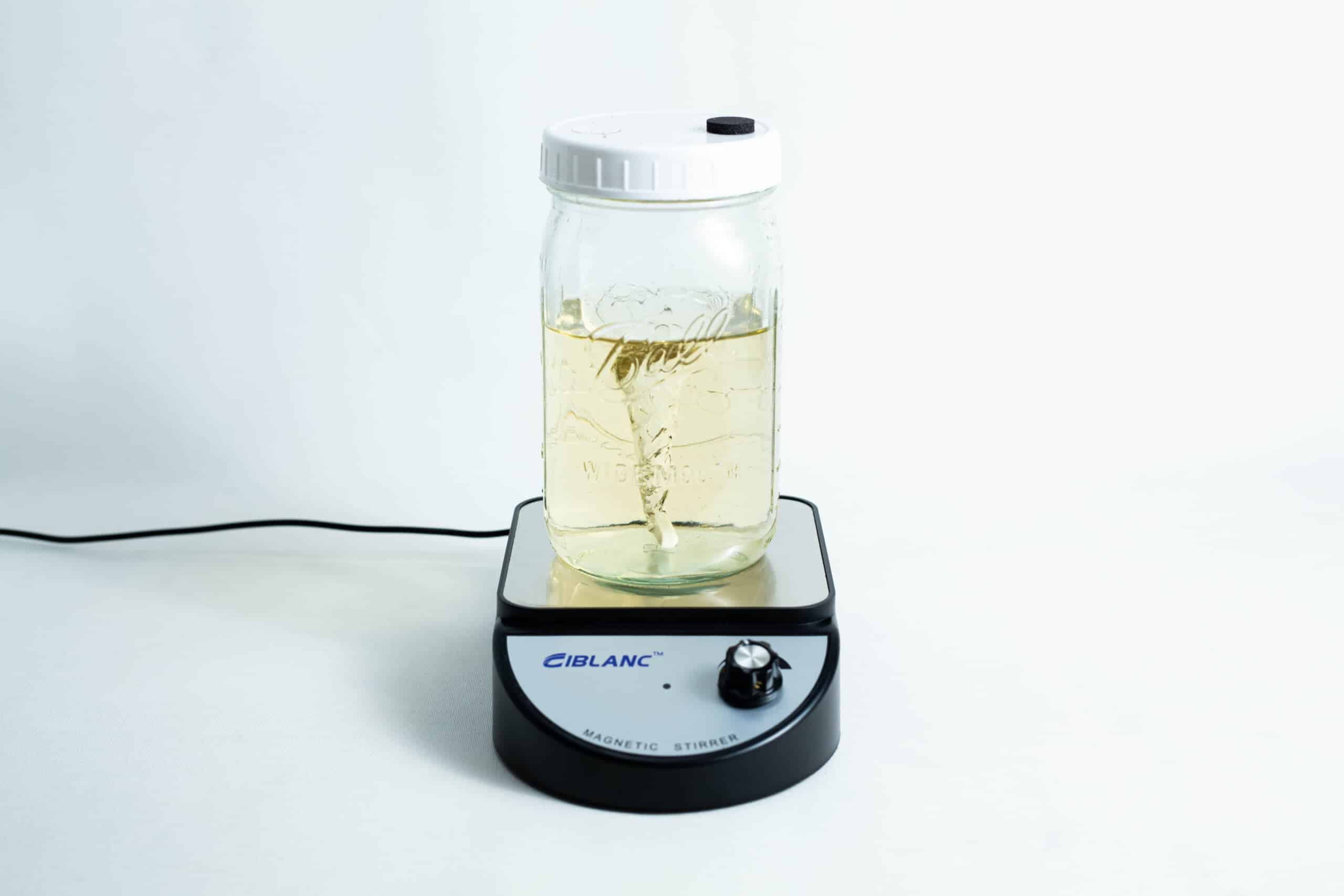A jar of liquid is being mixed on a Magnetic Stirrer Ciblanc 3500rpm, shown against a plain white background.
