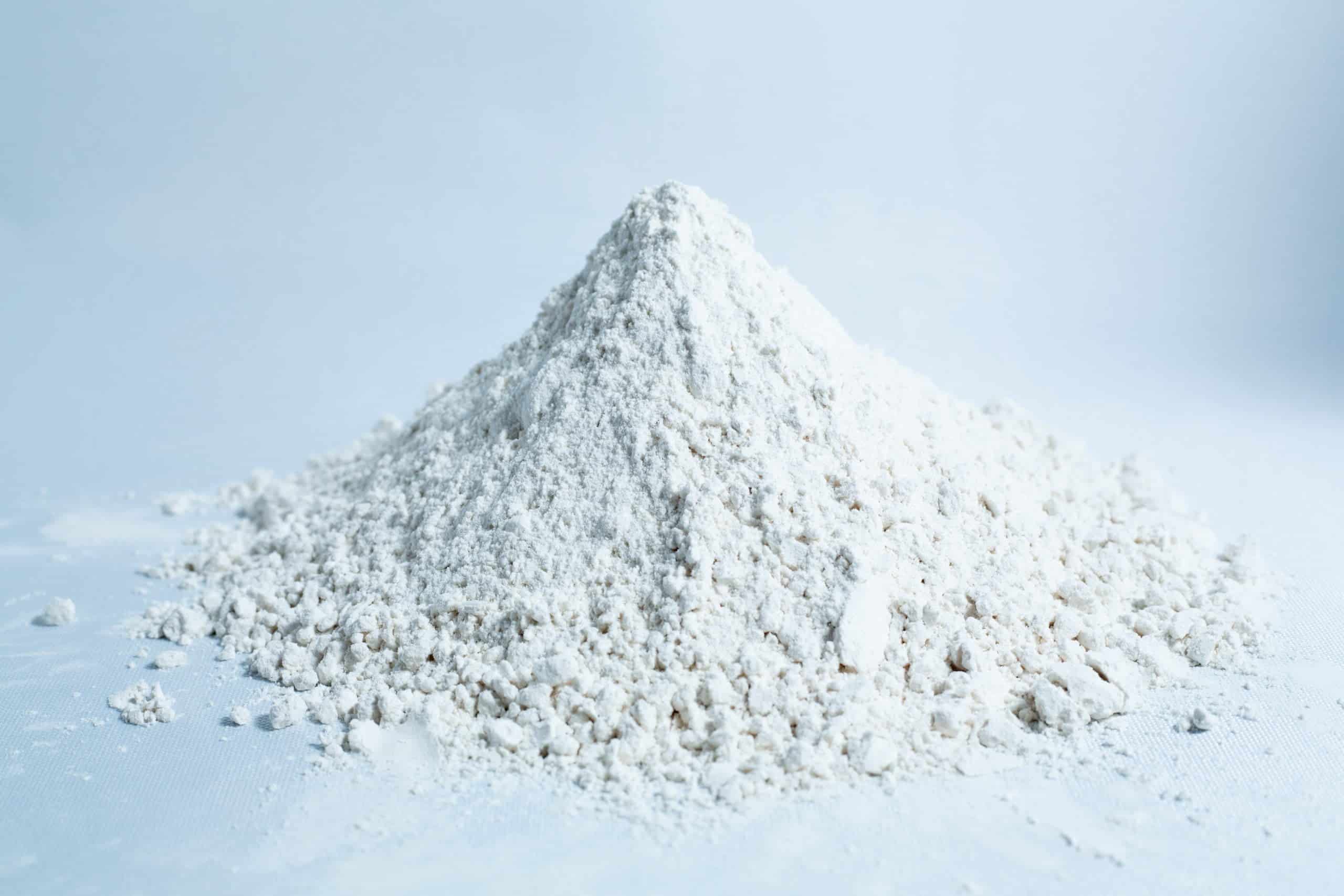 A small mound of Brown Rice Flour 5kg Organic Food Grade on a white surface with a light background.