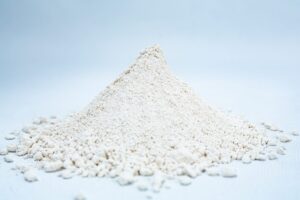 A small mound of fine, off-white Liquid Culture Pre-mix | DLME | Now Extra Clear powder rests on a light surface with a plain background.