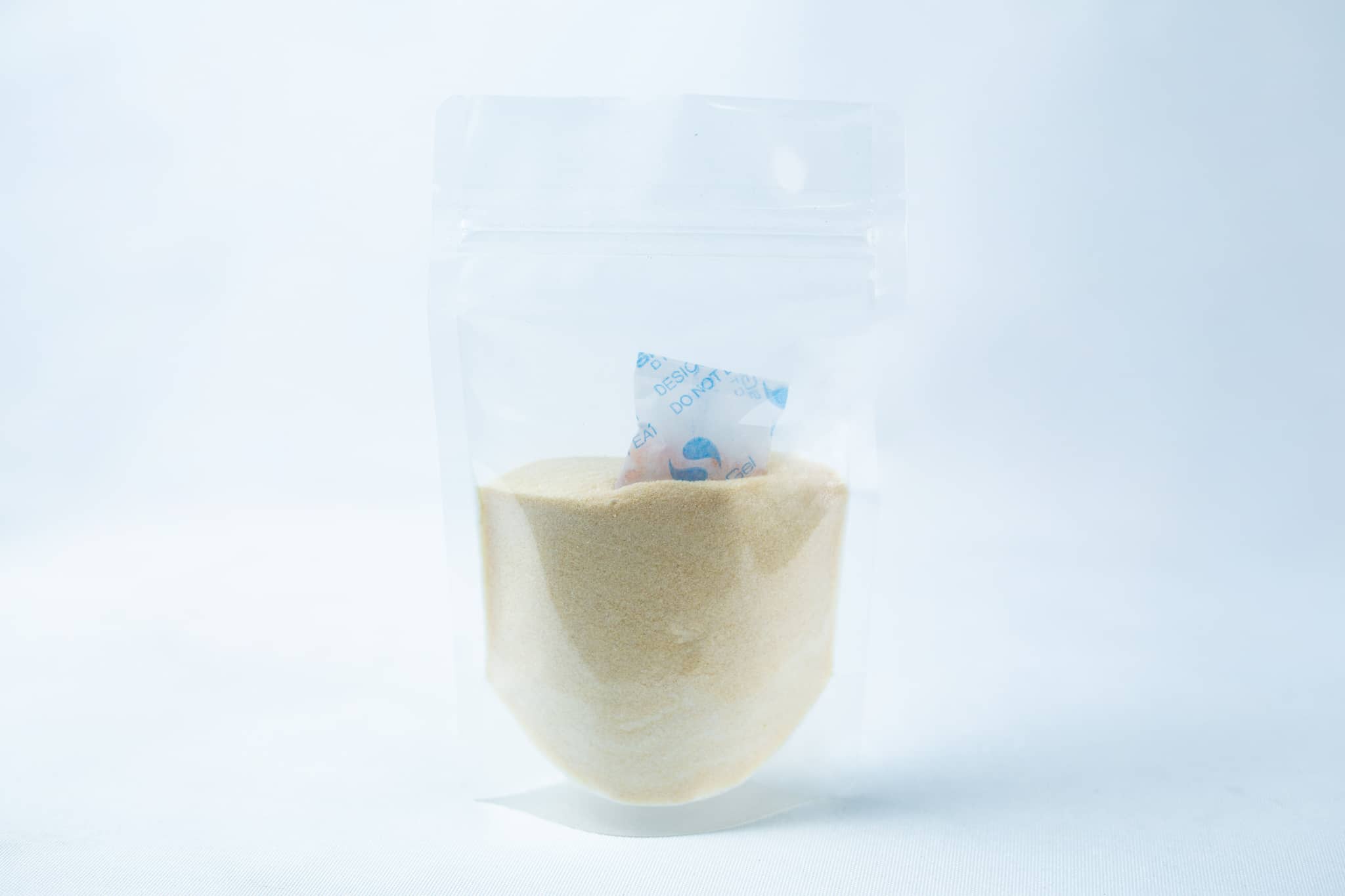 A transparent pouch of Liquid Culture Pre-mix | DLME | Now Extra Clear, containing light yellow dextrose and light malt extract powder, with a small silica gel sachet inside.