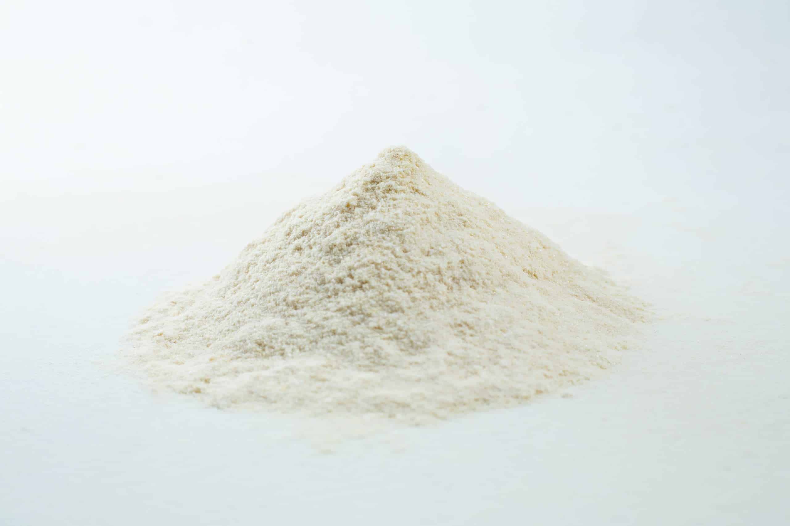 A small mound of white powder, likely the Agar Mix MYAG Antibacterial Malt Extract Yeast, on a plain white surface.
