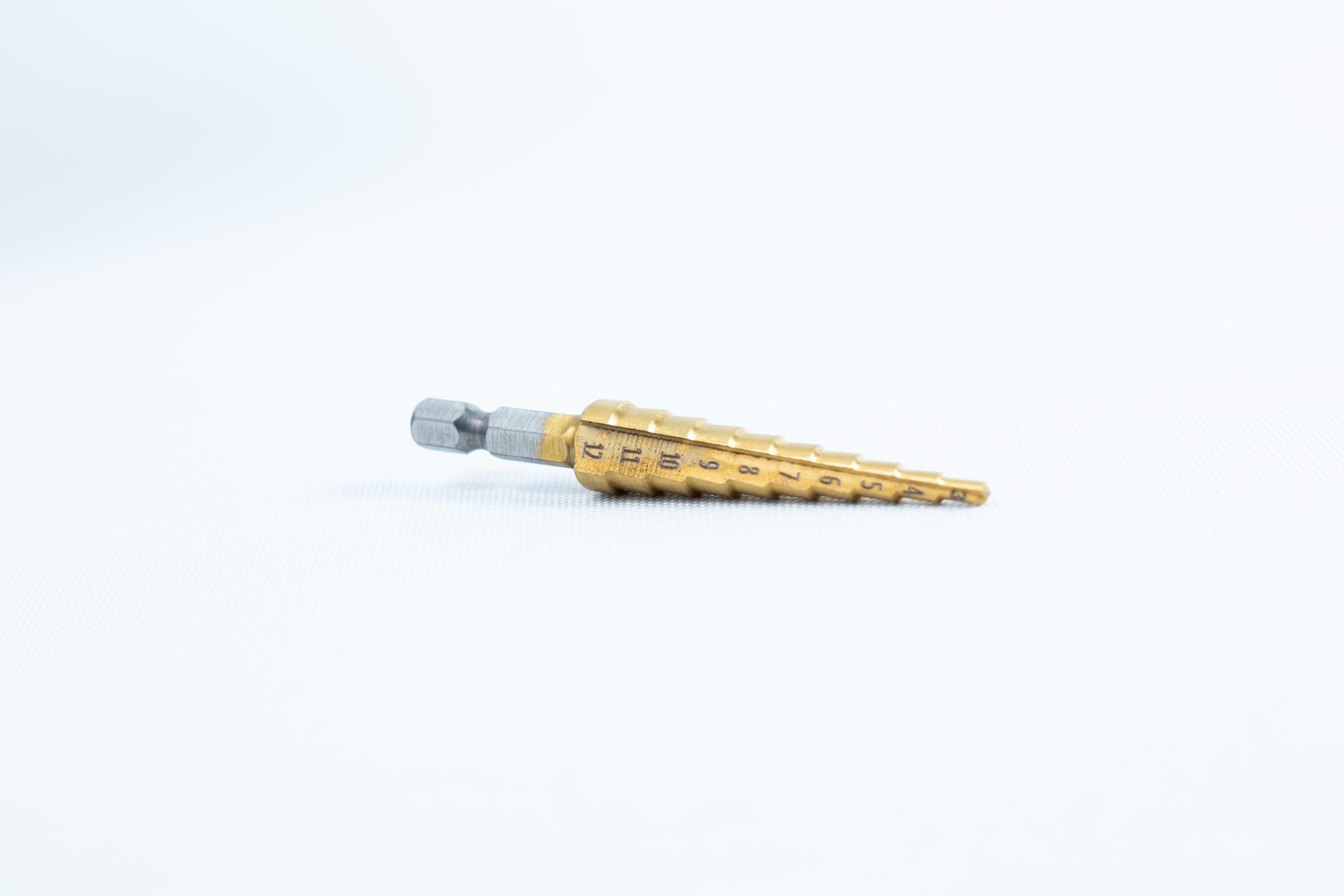 A Drill Bit for holes size 3mm–12mm, Titanium Coated with size markings, is shown lying on a plain white background.