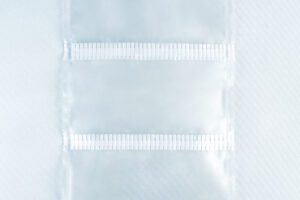 Three empty Unicorn Mushroom Grow Bags for spawn and substrate, made of transparent plastic with horizontal seals, are laid flat on a white background.