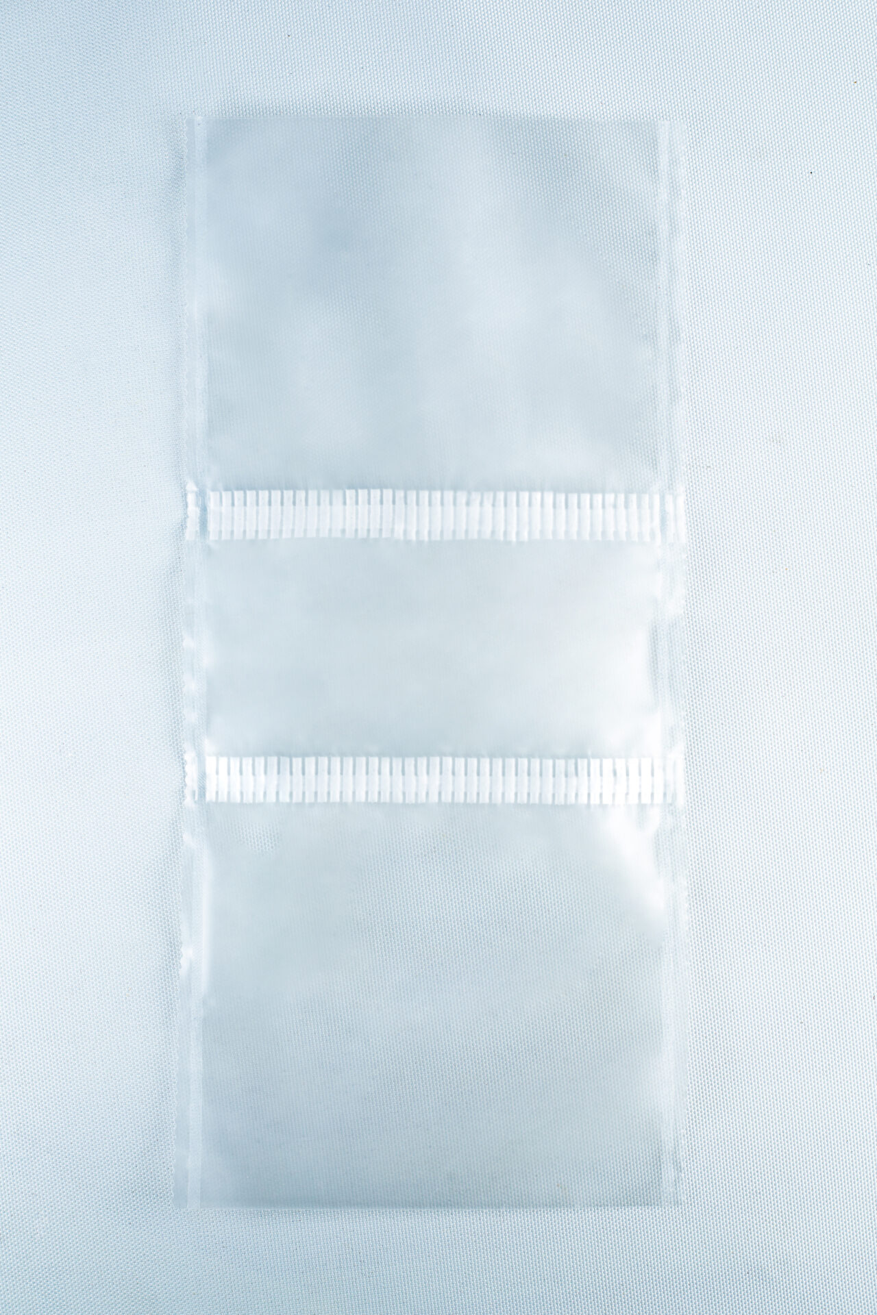 Three empty Unicorn Mushroom Grow Bags for spawn and substrate, made of transparent plastic with horizontal seals, are laid flat on a white background.
