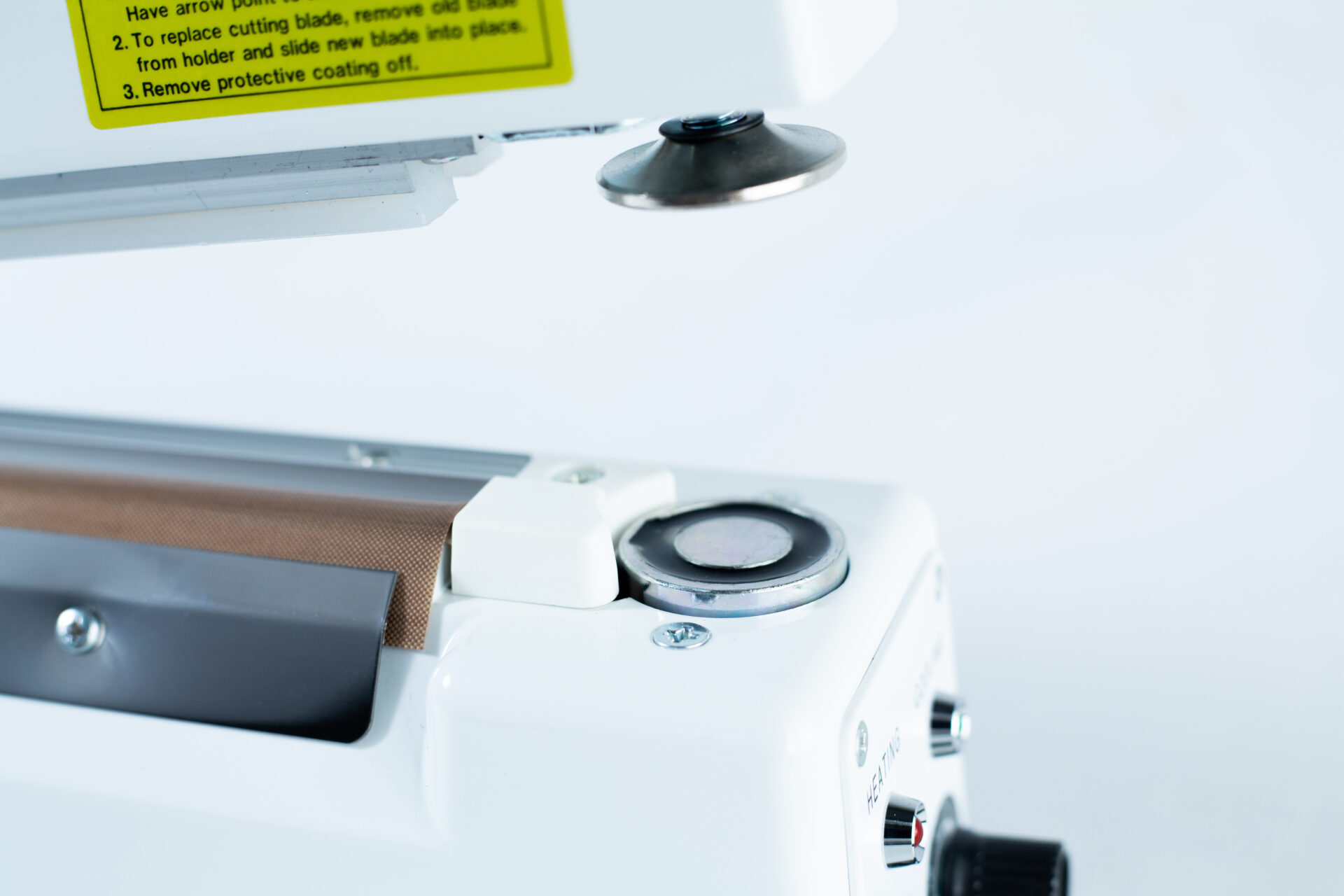 Close-up of the Heat Sealer 30cm Seal Width 5mm with cutter and magnet, highlighting its metal and plastic parts against a plain background.