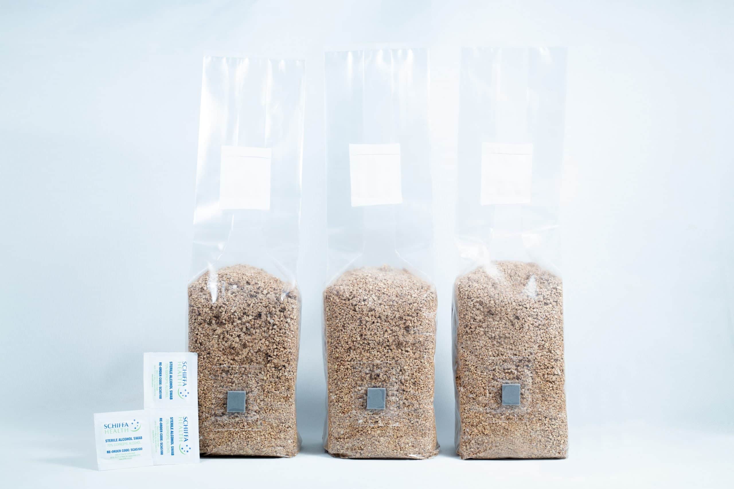 Three 1kg Organic Brown Rice Flour (BRF) & Vermiculite bags for PF Tek sit beside two silica gel sachets on a white background.
