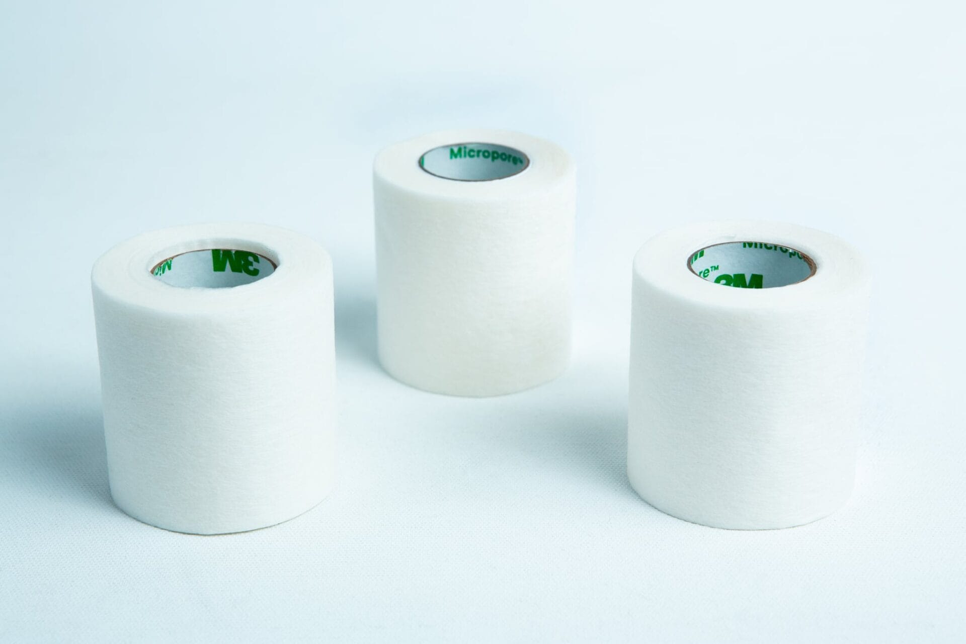 Three rolls of Micropore tape Mycology autoclavable breathable stand upright on a white surface, highlighting the gentle, secure, and breathable medical tape suitable for mycology and sterilisation needs.
