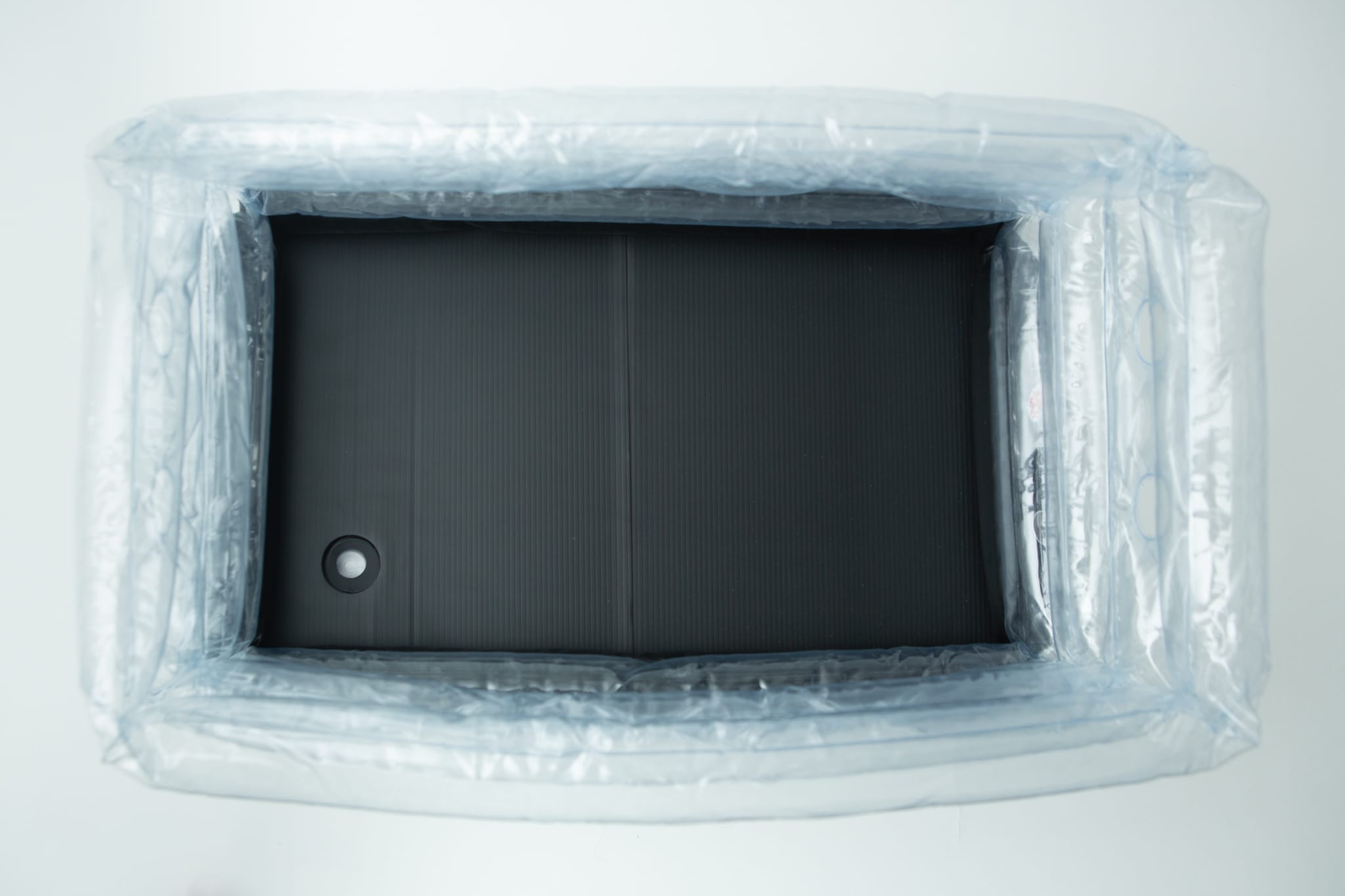 Top view of an empty inflatable monotub kit for growing mushrooms—Boomer Shroomer V 2.0—with a black rectangular base inside, resembling part of a mushroom grow kit.