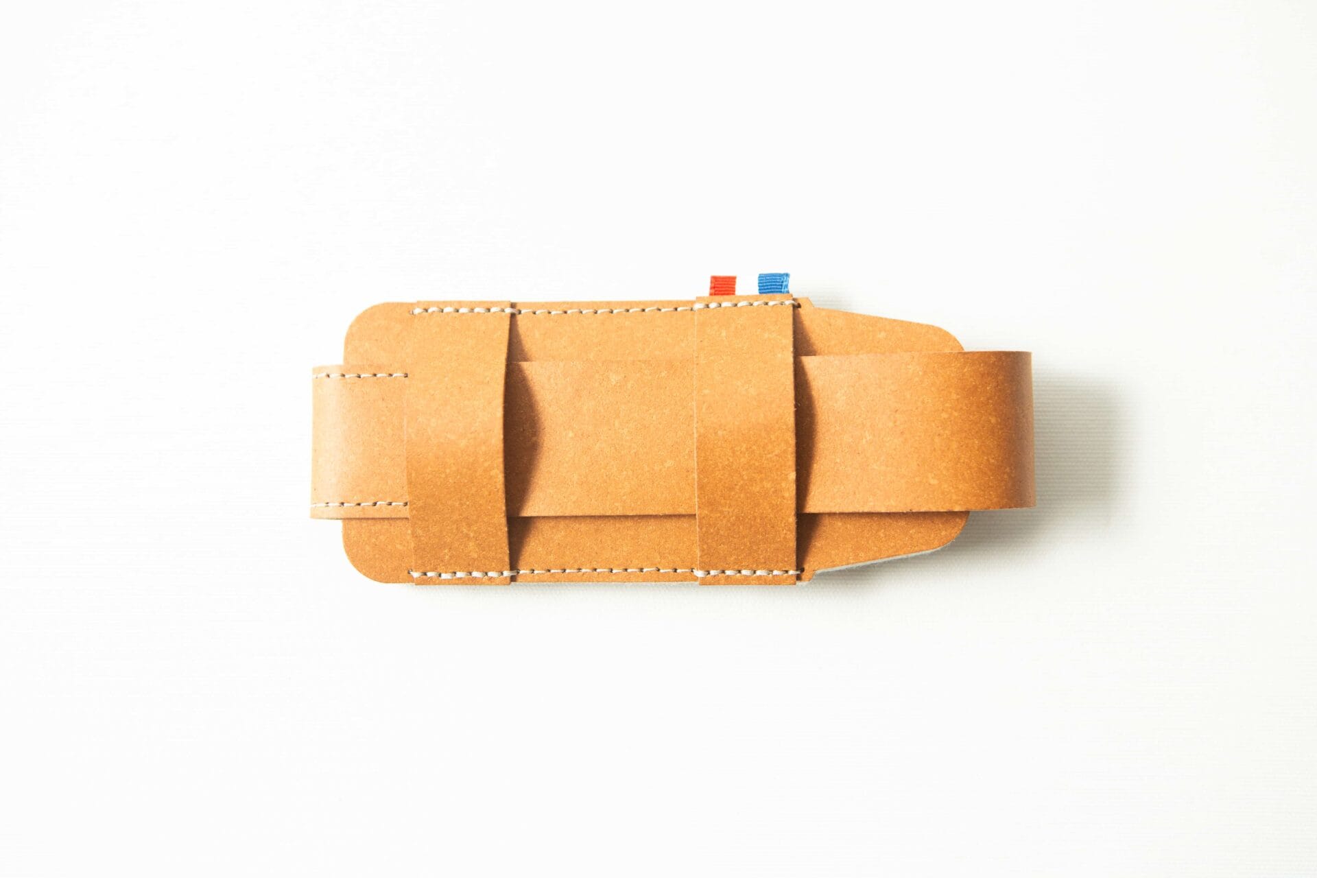 Minimalist brown leather Opinel Sheath with visible stitching, set against a white background—showcasing refined craftsmanship.