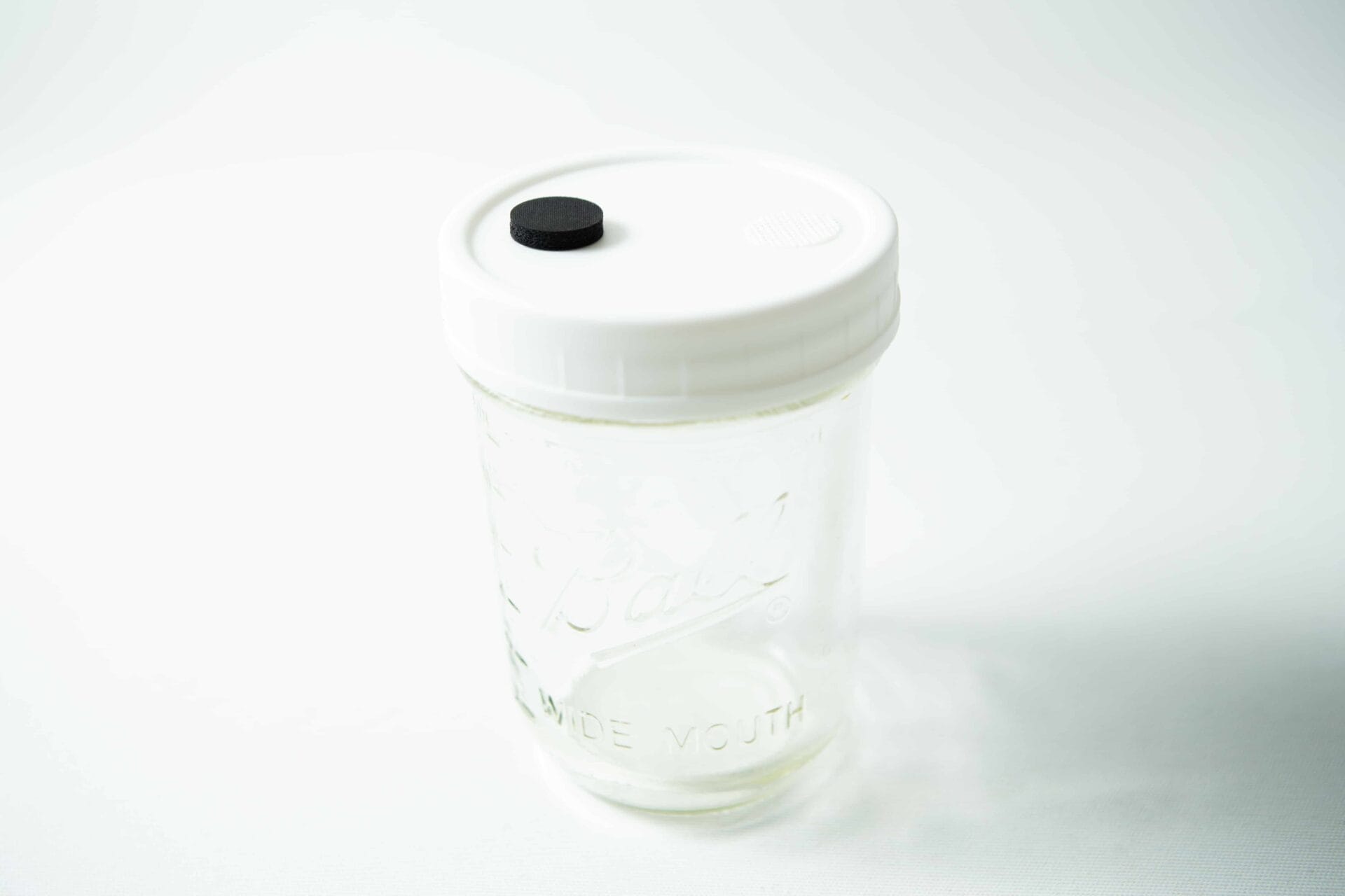 A clear Kilner jar with a white lid featuring an injection port and air filter, set against a white background—ideal for use with Mycology pre-made Wide Mouth Kilner Jar Lids (white with injection port and air filter).