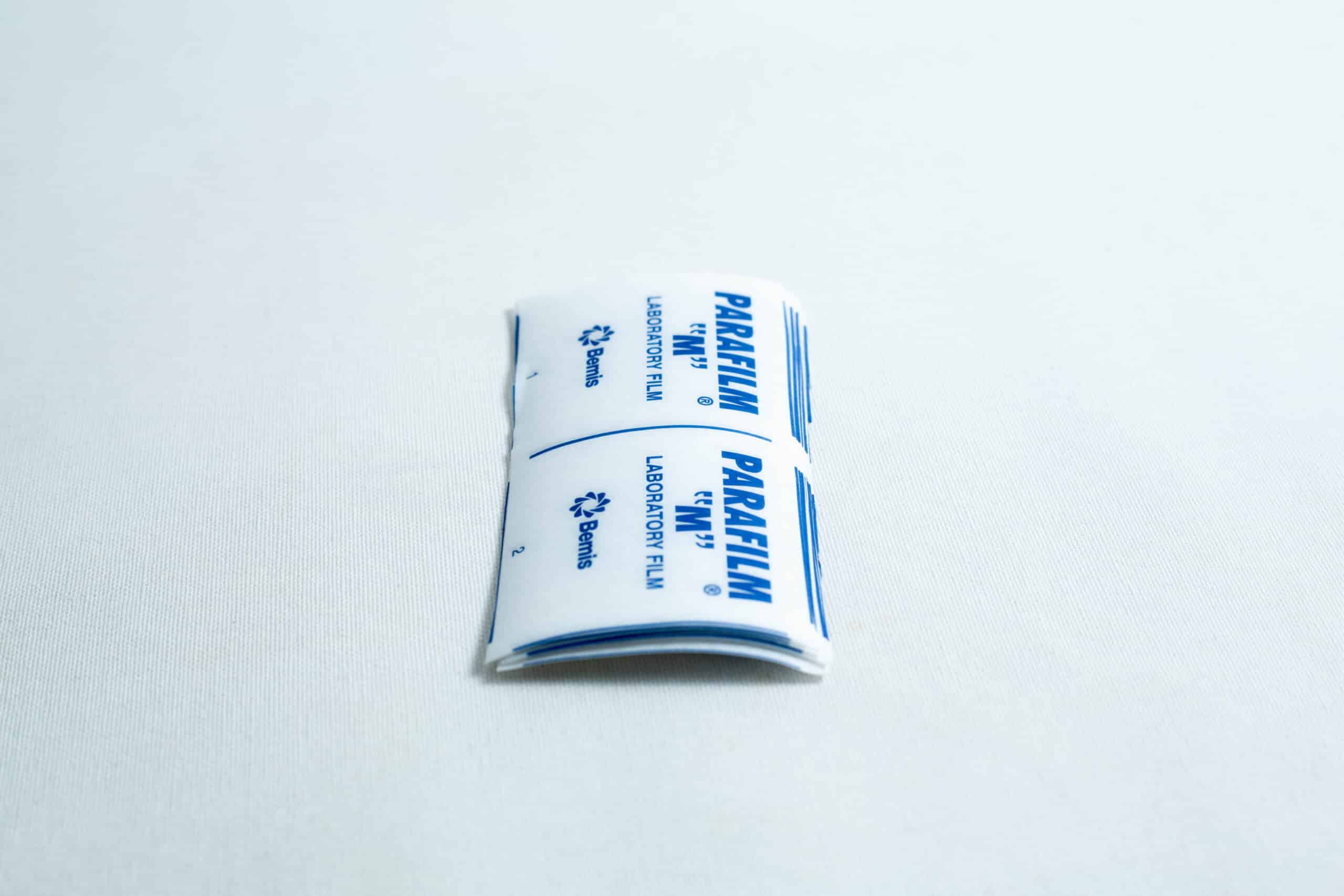 Pre-cut Parafilm strips 10x lab cut film rest on a white surface, making it easy to quickly seal lab containers without the need to cut Parafilm strips by hand.
