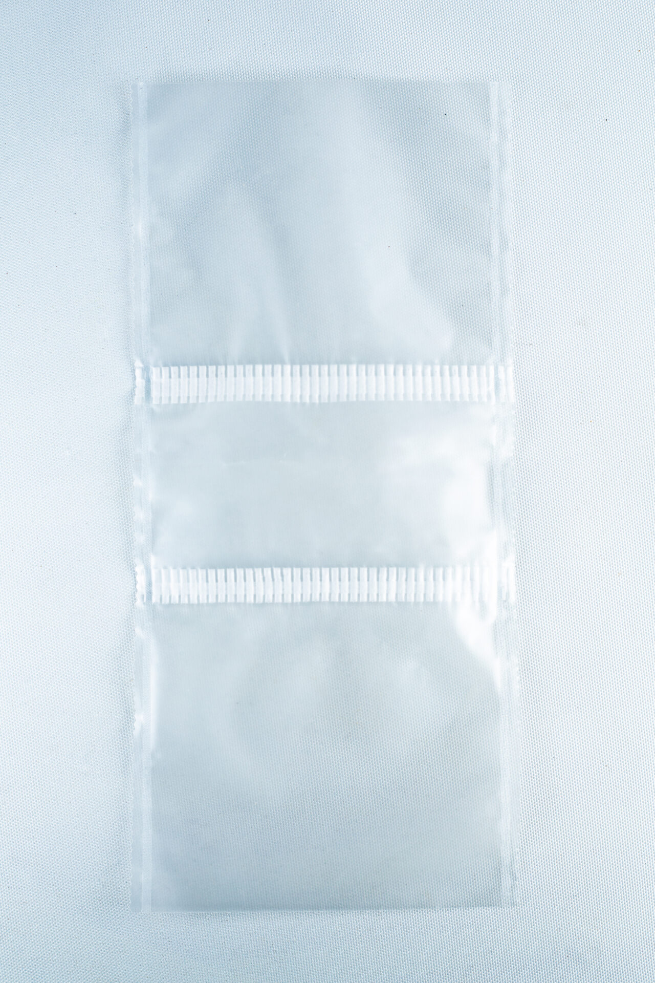 Two empty, clear Mushroom Grow Bags Unicorn for spawn and substrate are joined by a perforated line and placed on a plain white surface.