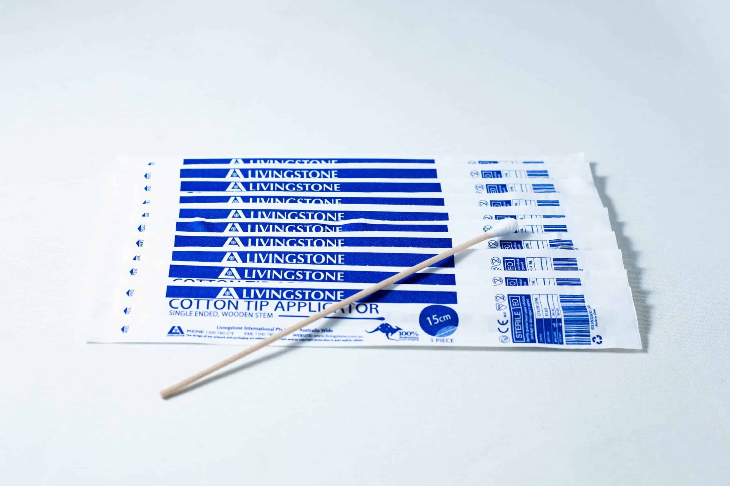Eight packs of Sterile Cotton Tip Applicator/Swab in blue and white, each containing one sterile cotton tip swab, with a single wooden applicator on top.
