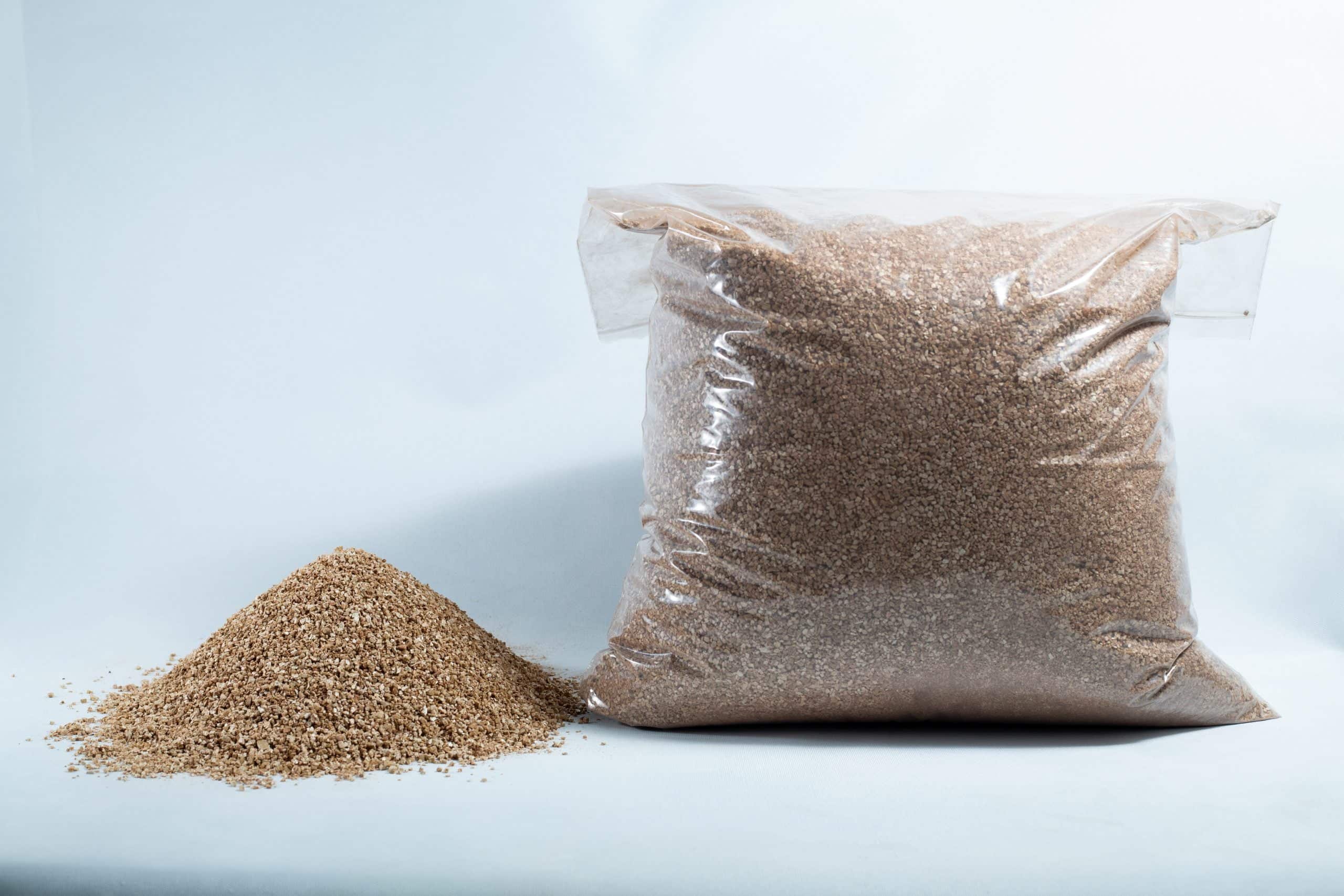 A clear plastic bag labelled "Vermiculite, Grade 2, fine, mycology" sits beside a small pile of brown grains on a white background.