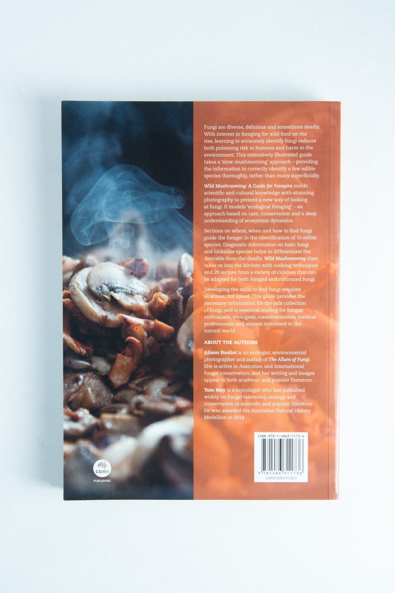 Back cover of Wild Mushrooming: A Guide for Foragers Book by Alison Pouliot and Tom May, showing steaming cooked mushrooms and text about fungi and this expert foraging guide.