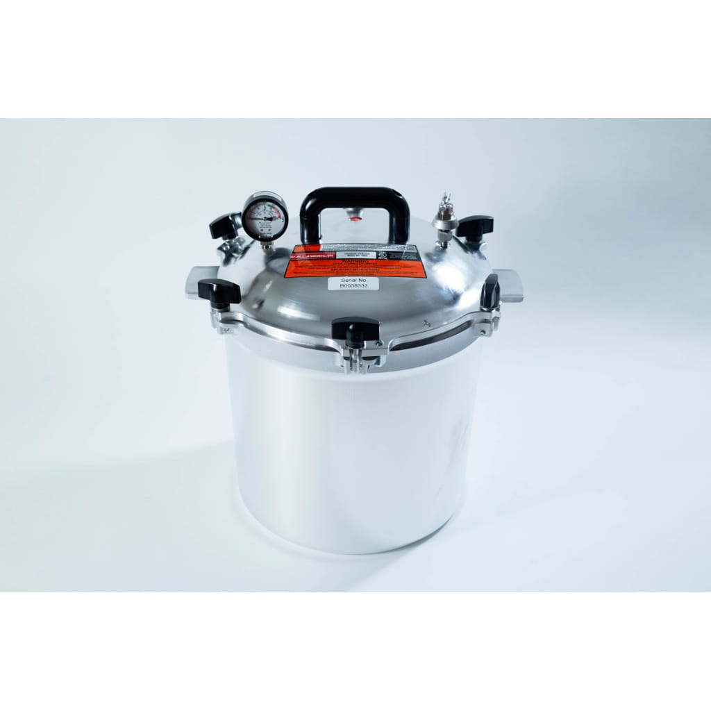 A stainless steel pressure cooker with a gauge, handle, and safety valves on a white background.