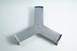 Grey metal Y-shaped object with THIS SIDE UP 4180 stamped in the centre, on a plain white background.