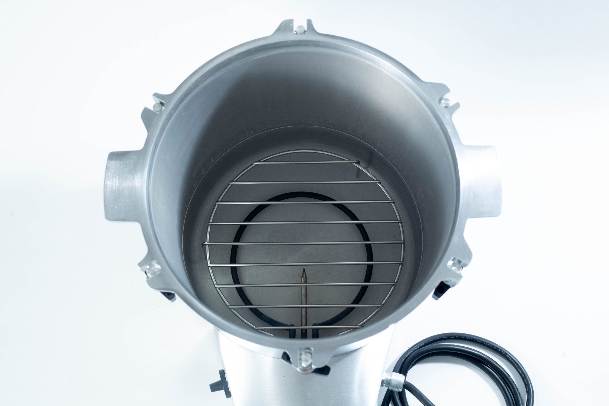 Top-down view of an empty metal canister with a wire rack and a black power lead on a white background.