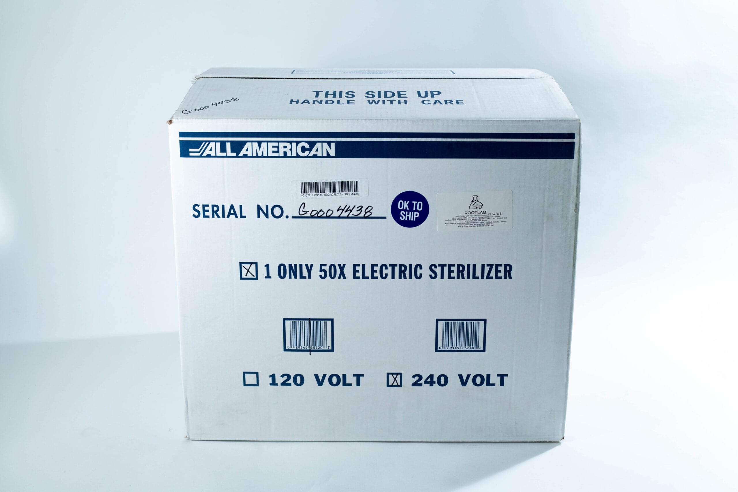 White box labelled All American for a 50X electric steriliser, marked for shipping, with voltage options.