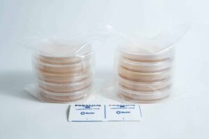Two stacks of 5 × Agar Plates (MEA) and 5 × Agar Plates (MEAG) pre-poured 90mm sit beside two packs of laboratory Parafilm on a white background.