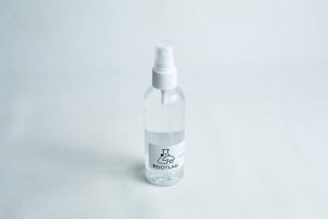 A clear 100ml spray bottle labelled ROOTLAB with a laboratory flask logo, containing 70% isopropyl alcohol, is placed on a white background.