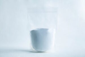 A clear resealable pouch filled with white powder, set against a plain white background.