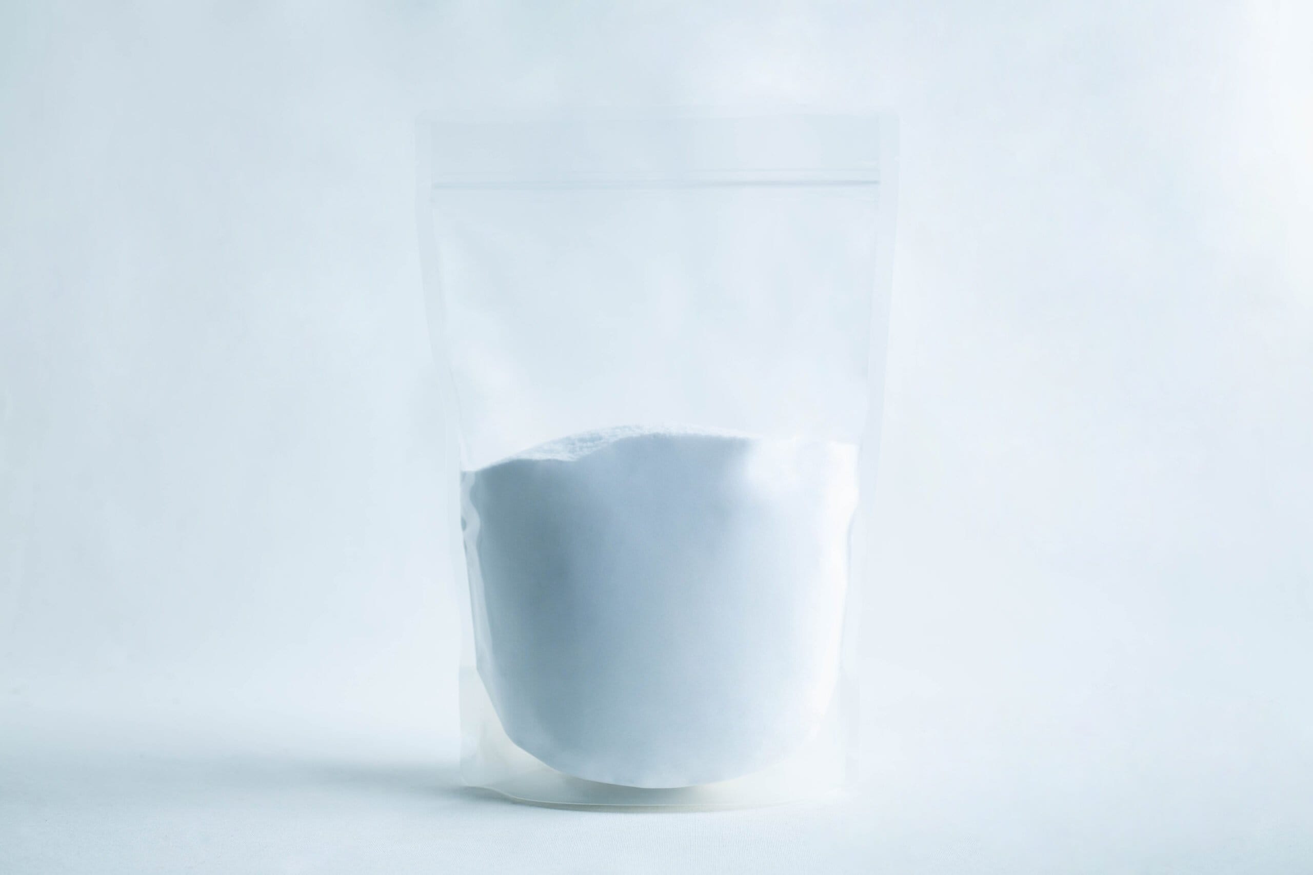 A clear resealable pouch filled with white powder, set against a plain white background.