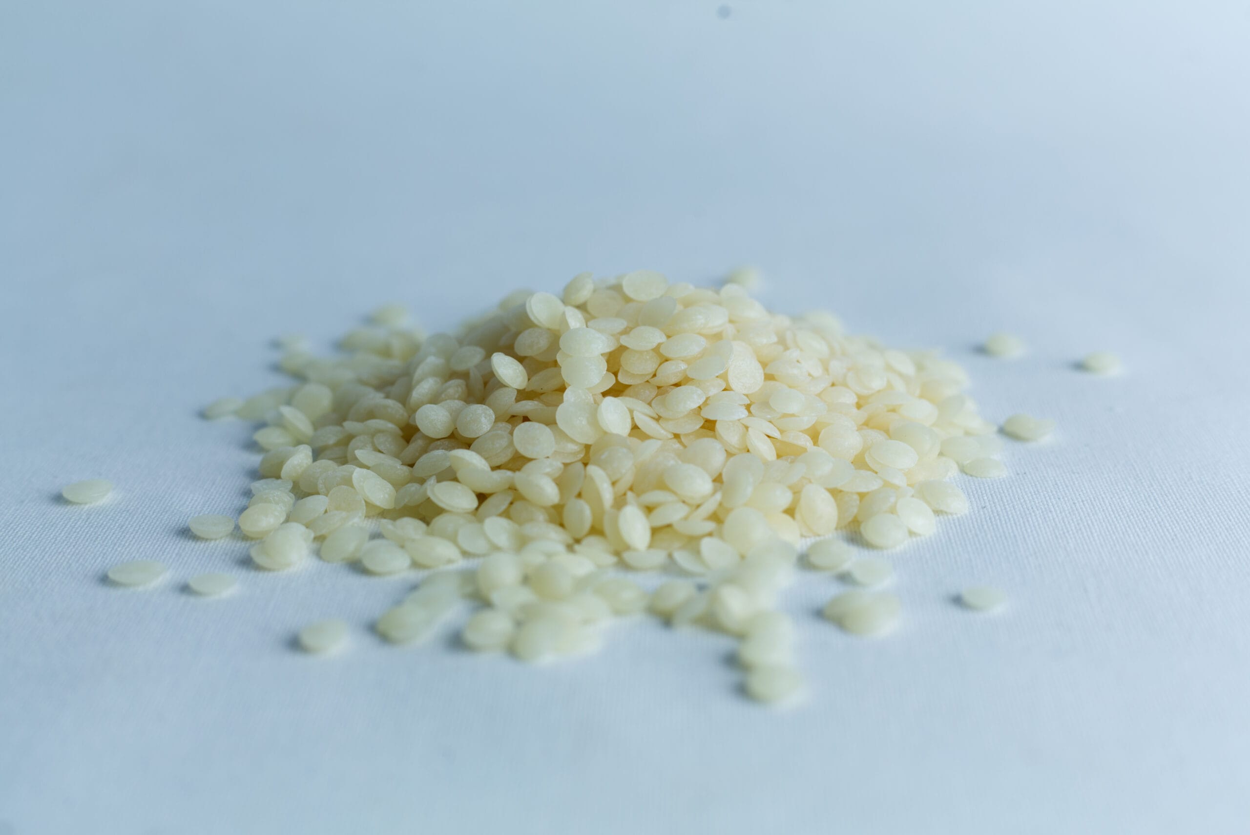 A small pile of uncooked white rice grains on a plain, light surface.