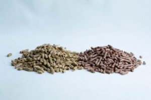 Two piles of brown and beige animal feed pellets on a white background.