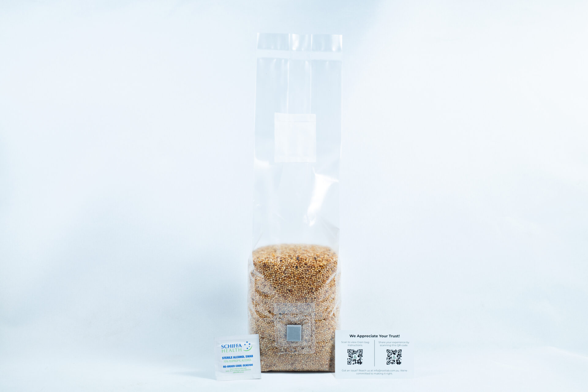 A clear plastic bag of millet pre-sterilised mushroom grains with injection port and digital instructions is shown with two business cards on a white background.
