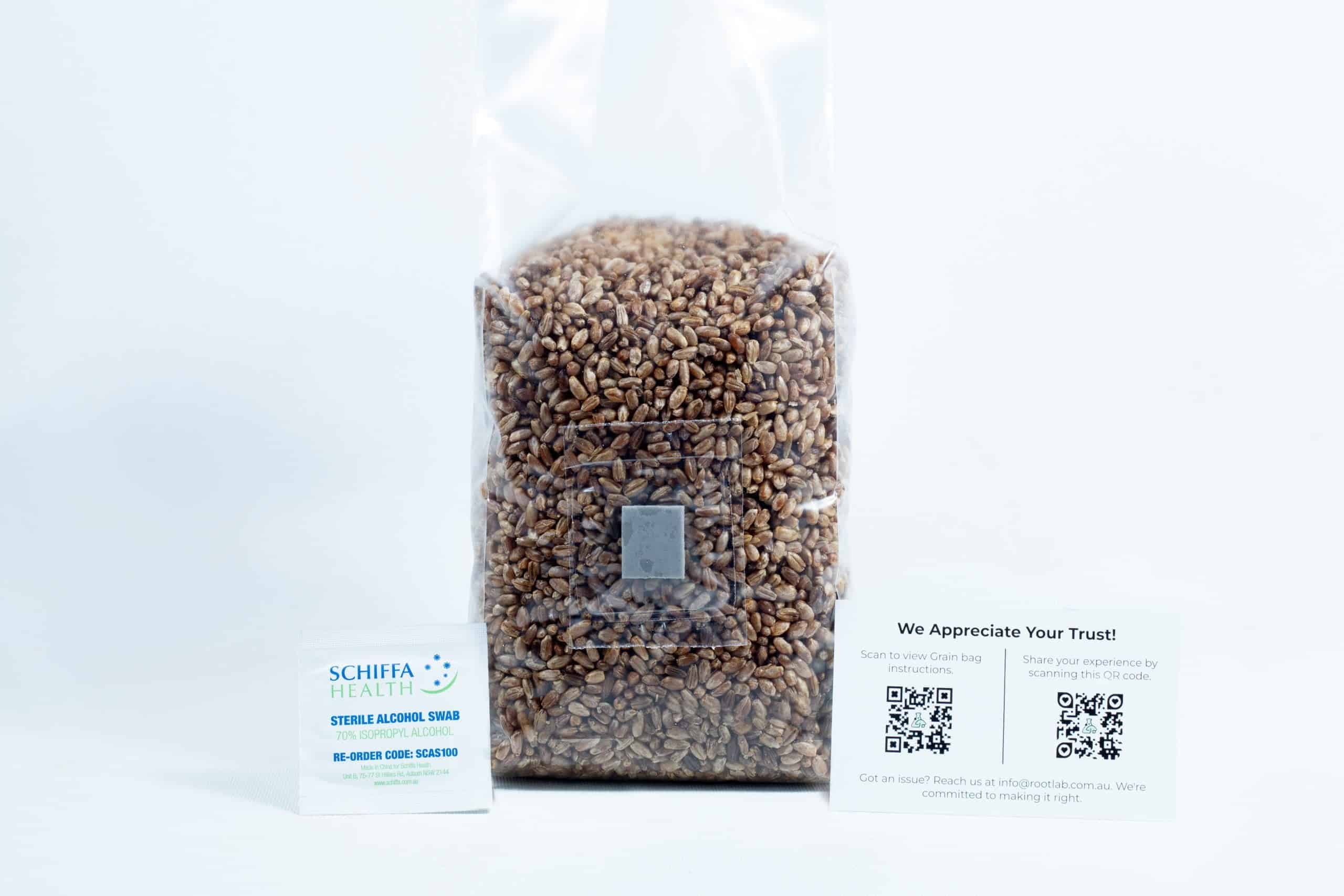 A clear bag of rye grain organic pre-sterilised for mushroom cultivation with injection port and air-filter is shown with two business cards in front on a white background.