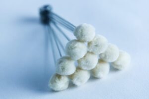 A cluster of white cotton buds arranged in a triangular formation on a light surface.