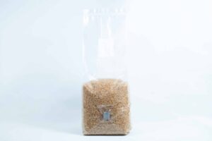 A clear plastic bag of Millet Pre-Sterilised Mushroom Grains with injection port and digital instructions, sealed at the top, shown on a white background.
