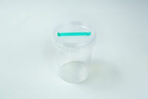 The Cordyceps militaris Mushroom Grow Kit is a clear plastic container with a transparent lid and a green object attached to the top for easy mushroom cultivation.