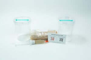 Two empty plastic containers, a wrapped item, syringe, and info card from the Cordyceps militaris Mushroom Grow Kit are arranged on a white background.