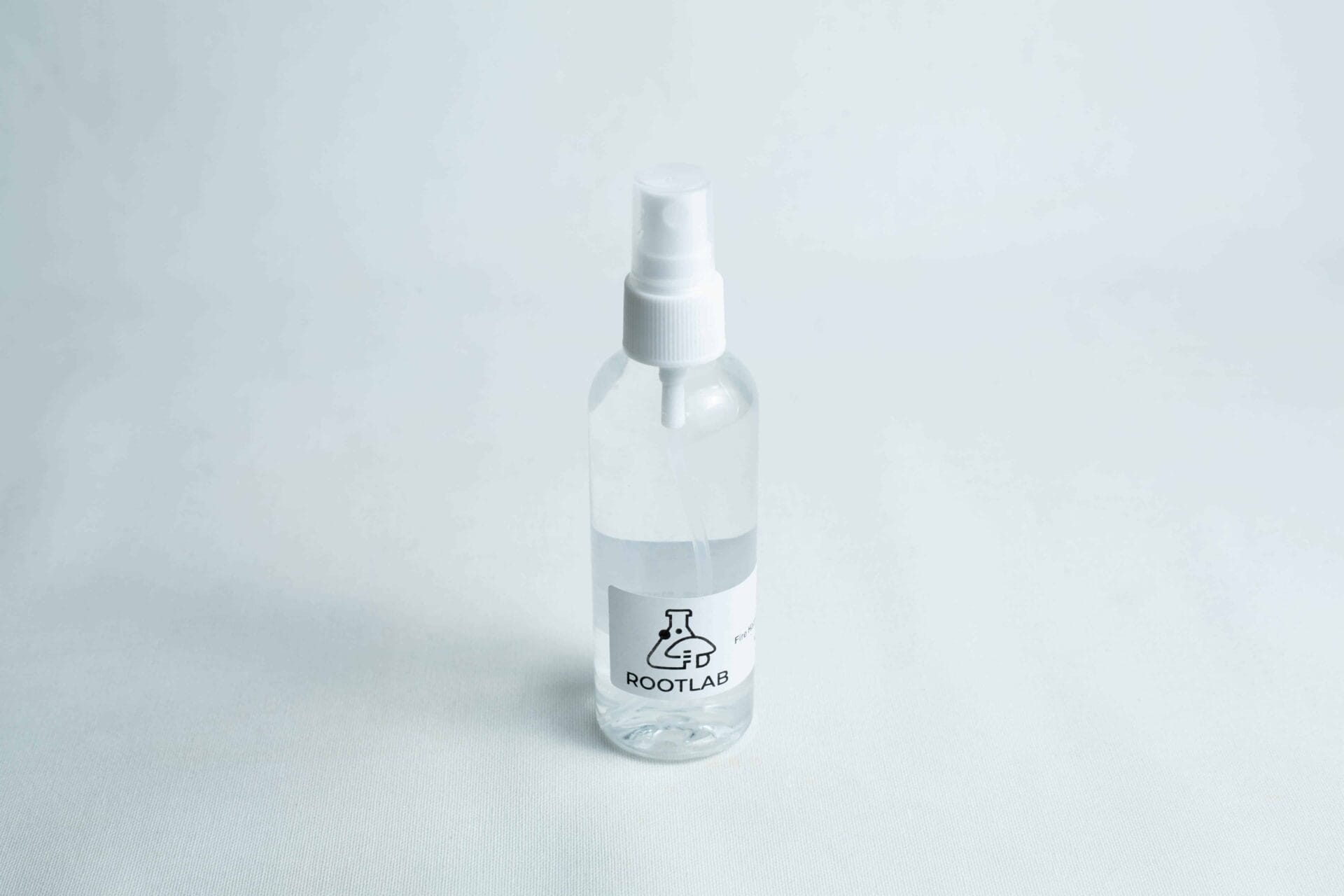 Clear plastic spray bottle labelled ROOTLAB filled with liquid, ideal for use with your Monotub Mushroom Growing Kit-Premium, shown on a white surface.
