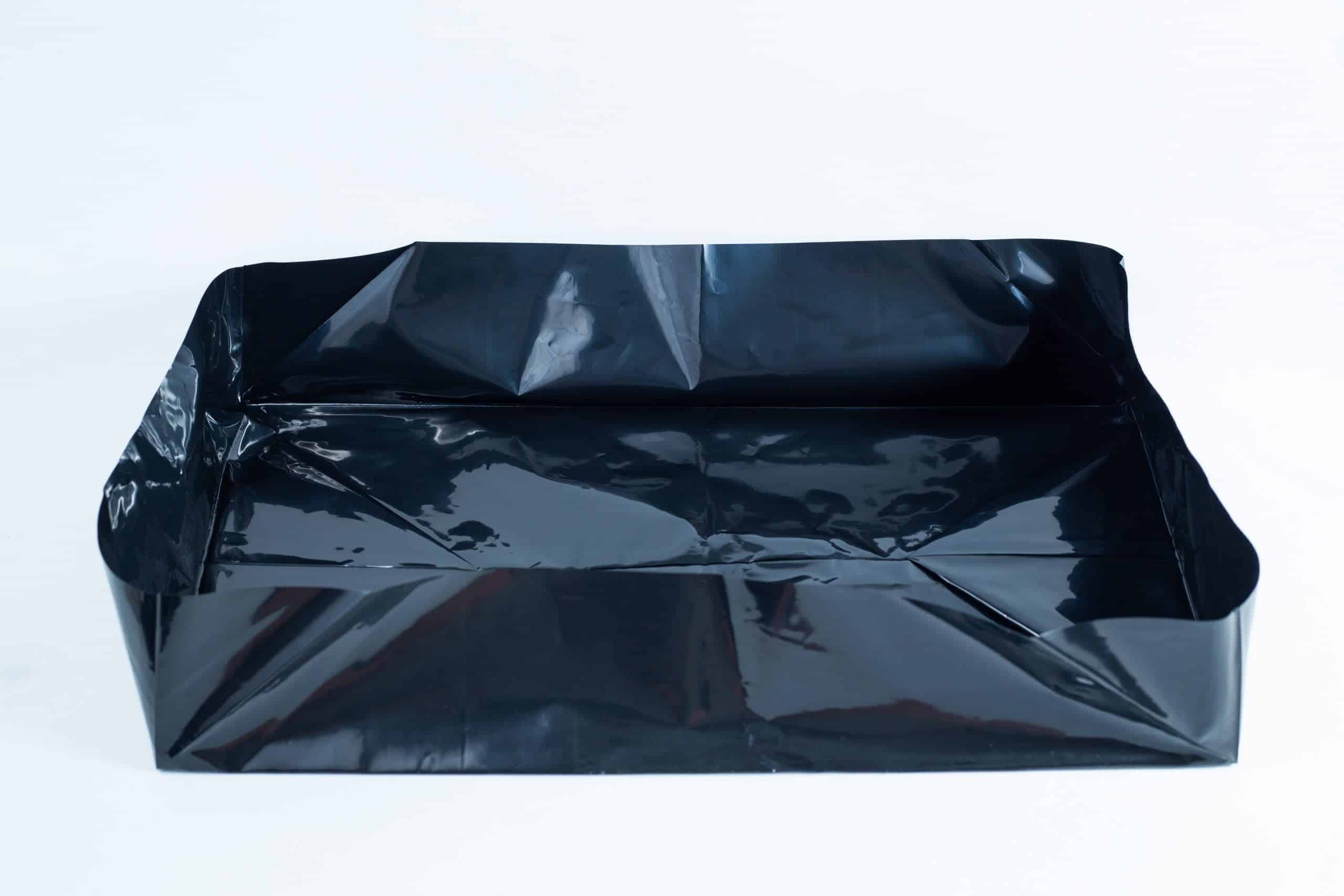 A black plastic sheet folded into a rectangular tray shape on a white background.