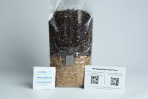A bag of soil and seeds, an alcohol swab sachet, and a card with QR codes on a white background.