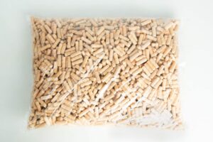 A clear plastic bag filled with small, cylindrical wooden pegs on a white surface.