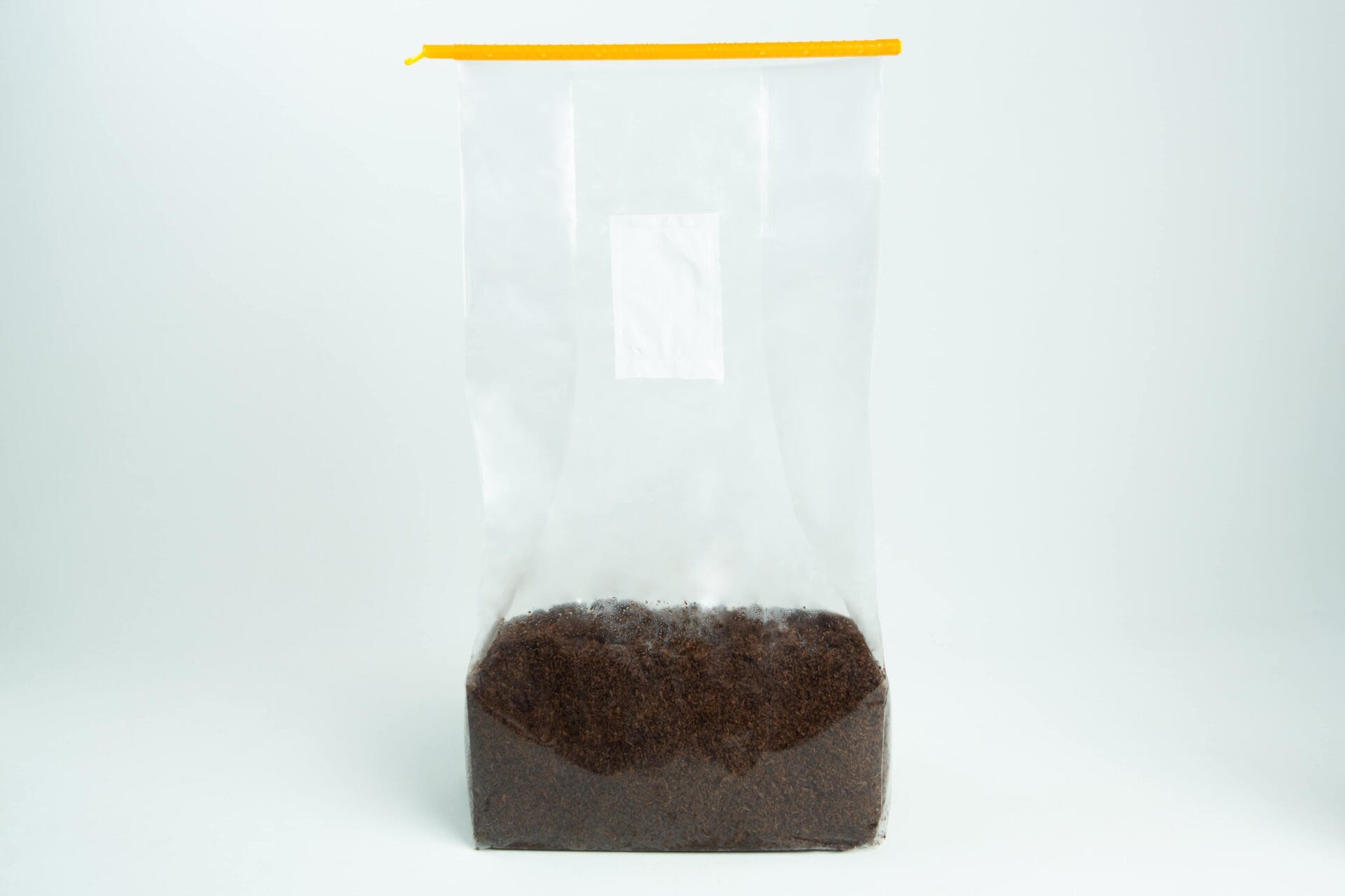 Clear plastic bag with a yellow zip, partially filled with loose black tea leaves.