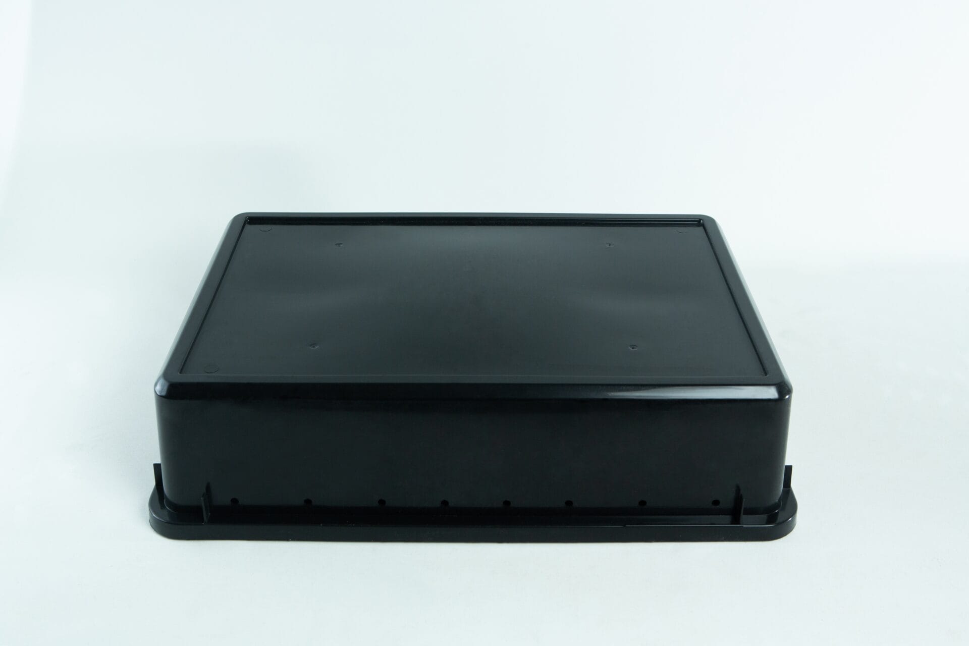 A black rectangular plastic container with a snap-on lid, placed on a white background.