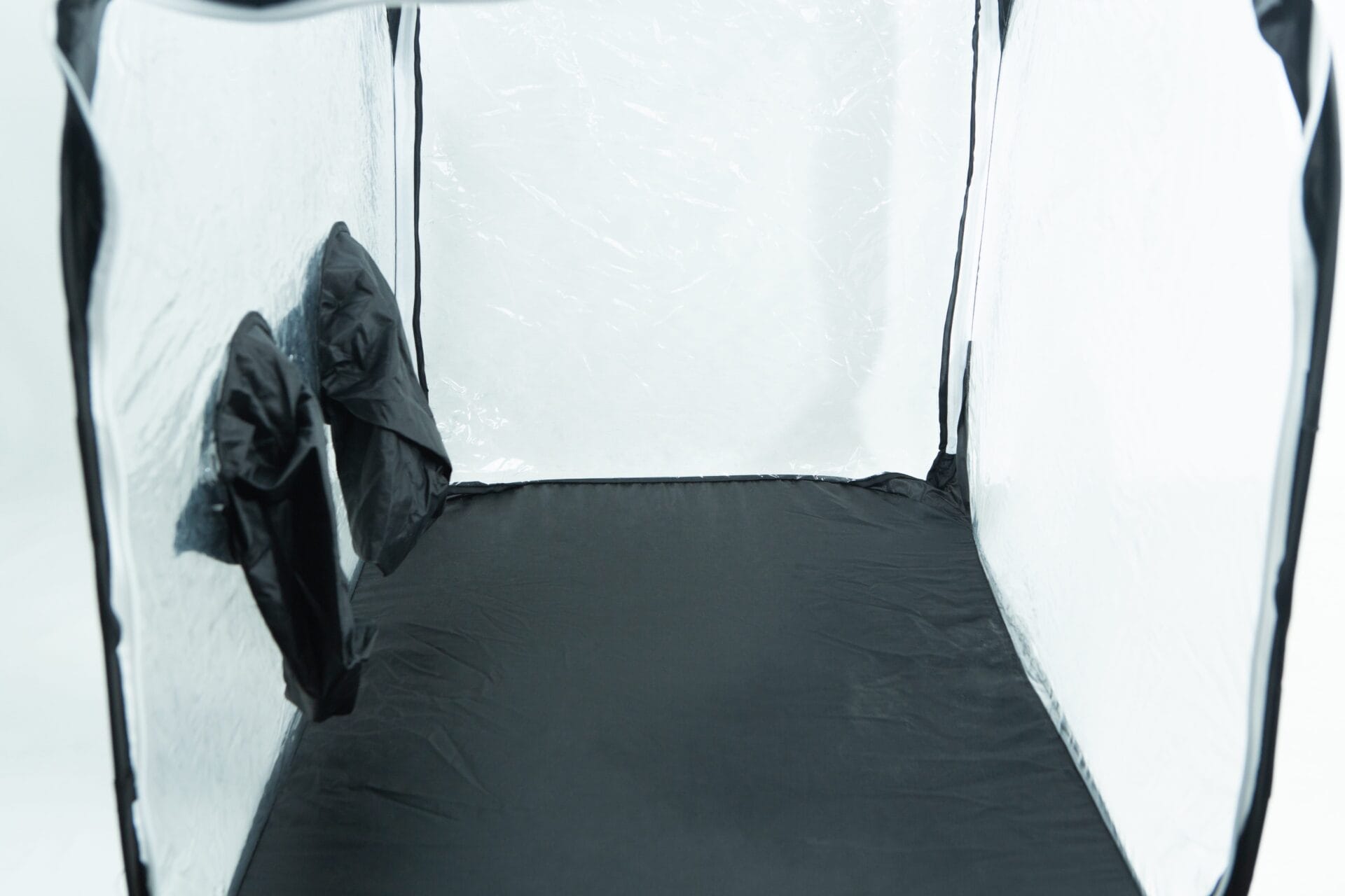 Interior of an empty grow tent with reflective walls and two vents on the left side.