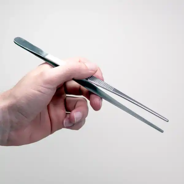 A hand holds metal tweezers, an essential tool included in the Plant Cell Tissue Culture Starter Kit, set against a plain, light background.