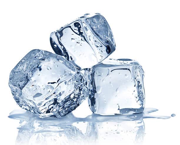 Three ice pack cubes are stacked together, each clear with water droplets and a small puddle forming at the base.