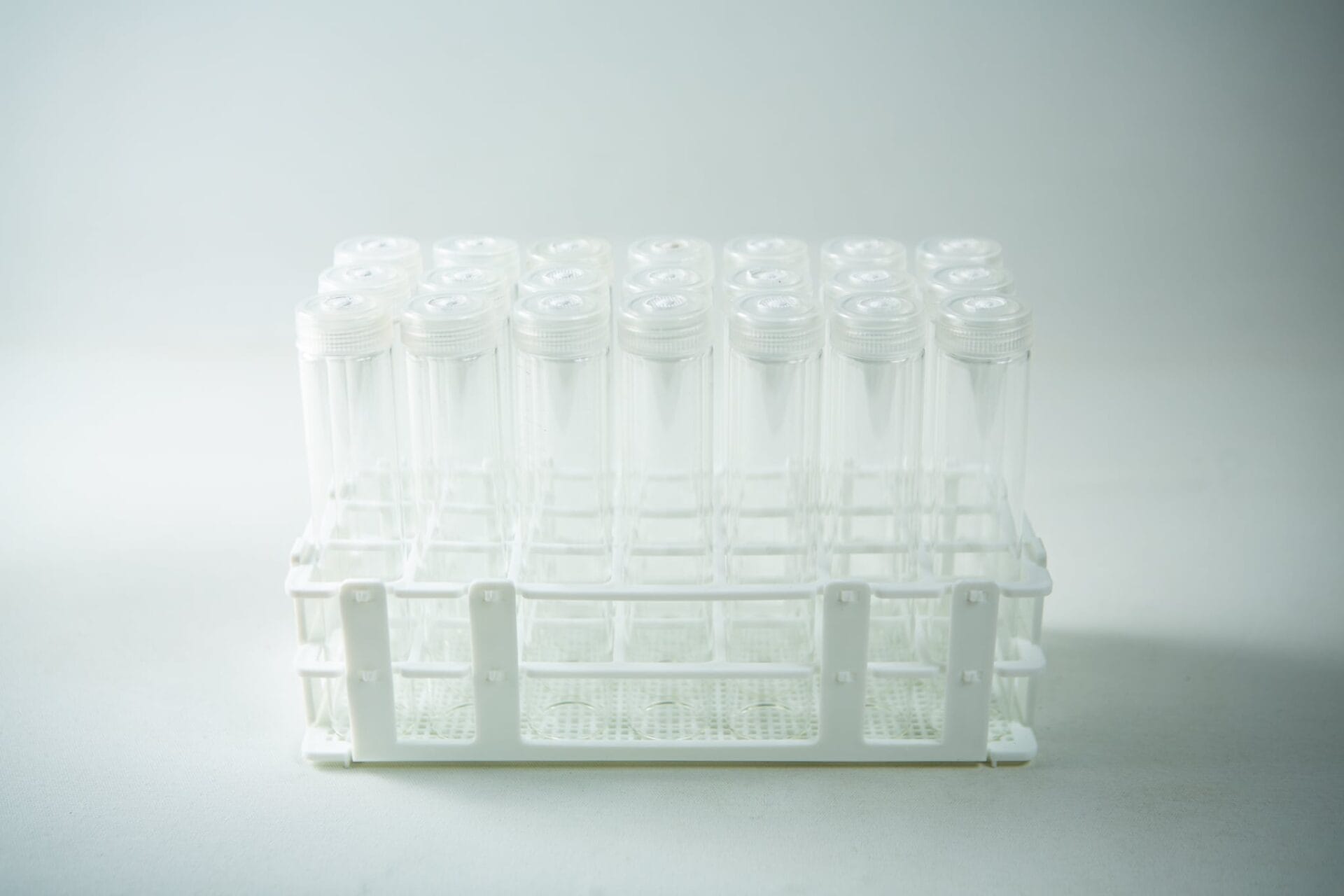 The Plant Cell Vented Plant TC Test Tubes with rack 12pc features a white plastic rack holding multiple clear test tubes with lids, displayed against a plain background.
